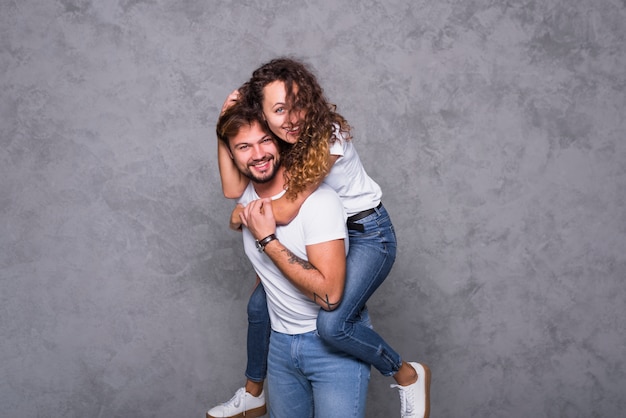 Happy woman sitting on man back