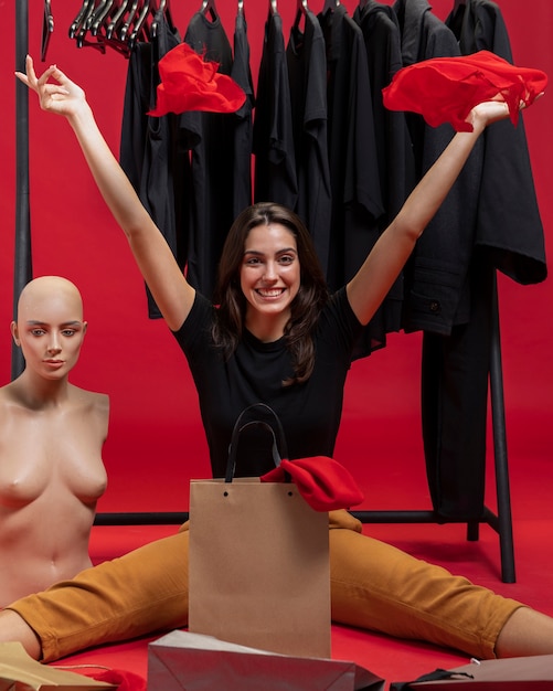 Free photo happy woman sitting next to mannequin