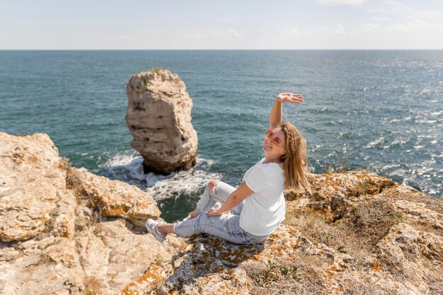 Happy woman sitting on rocks