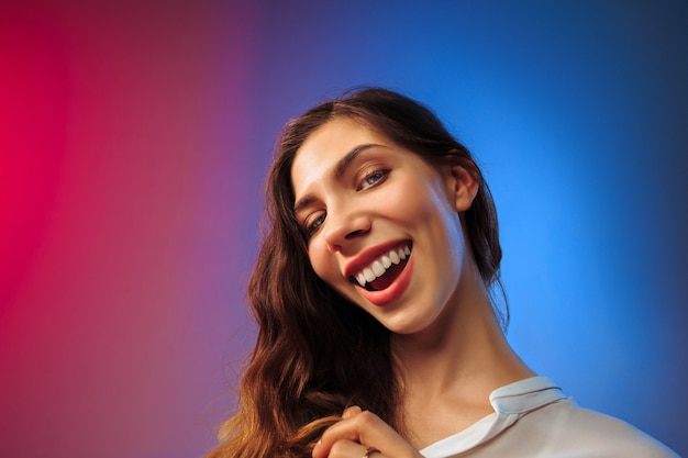 happy woman standing and smiling on colored wall