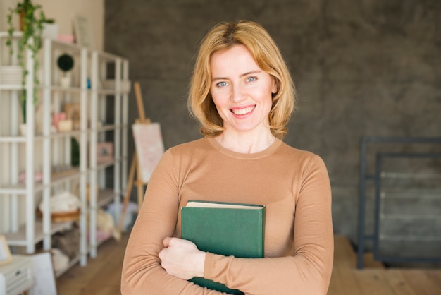 Happy woman standing with book 