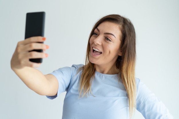 Happy woman taking selfie photo on smartphone. Happy lady having fun. 