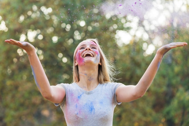 Free photo happy woman throwing color in the air