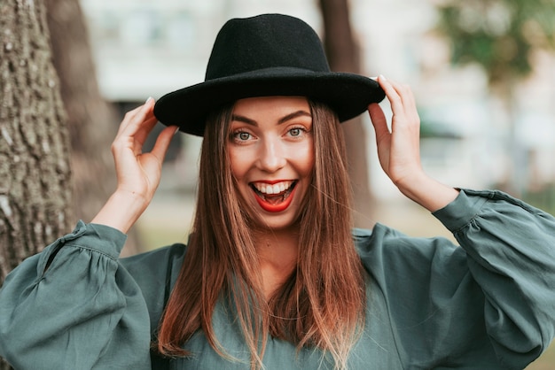 Free photo happy woman wearing a black hat