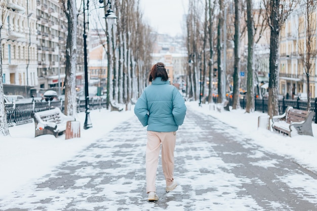 Free photo happy woman in winter on snowy city alley