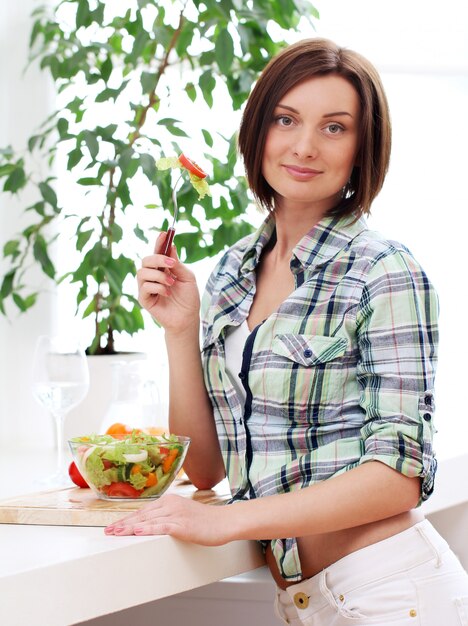 Happy woman with bowl of fresh salad