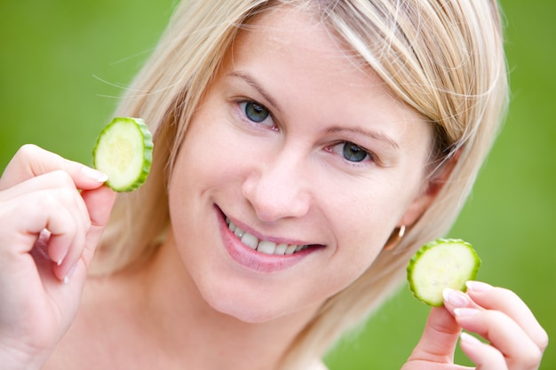 Free photo happy woman with cucumber slices