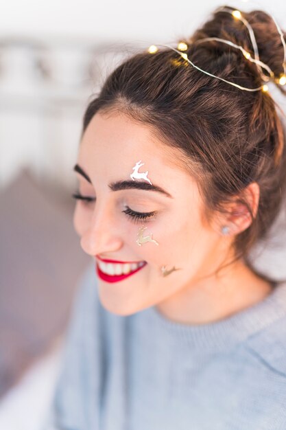 Happy woman with deer spangles on face