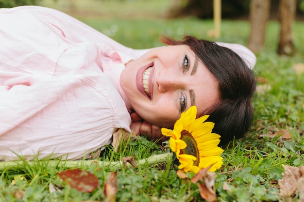 Happy woman with flower on grass