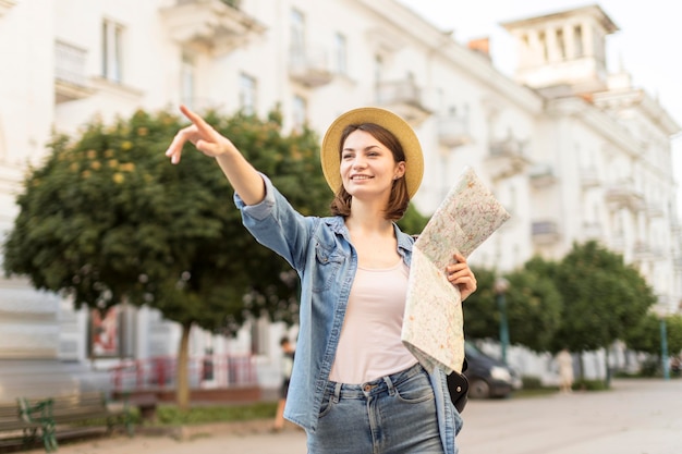 Happy woman with hat pointing at landscape