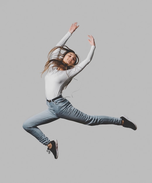 Free Photo happy woman with headphones jumping in the air