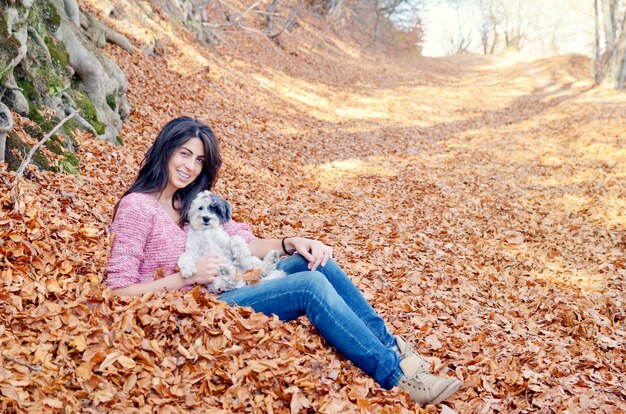 Happy woman with her dog on a fall day