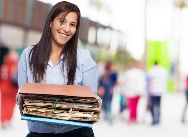 Happy woman with many papers and folders