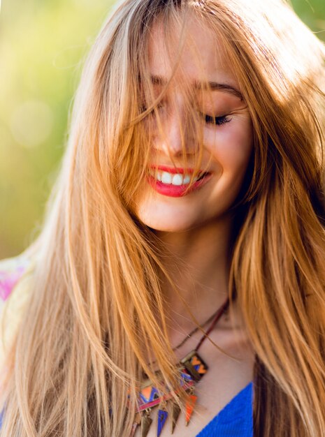 happy woman with windy blonde hair and closed eyes