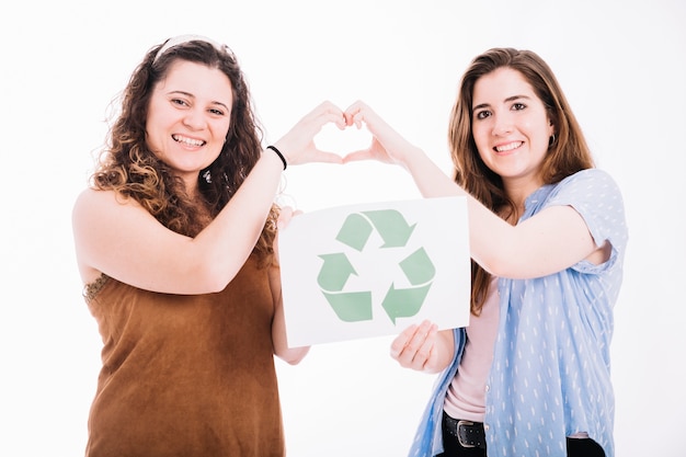 Free photo happy women holding recycle placard making heart sign with hands