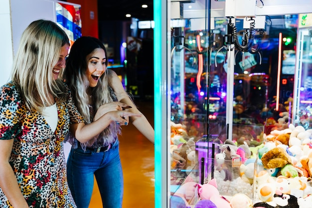 Free Photo happy women playing arcade machine