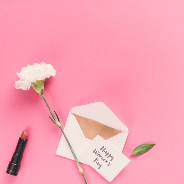 Happy Womens Day inscription with envelope and flower on pink table 