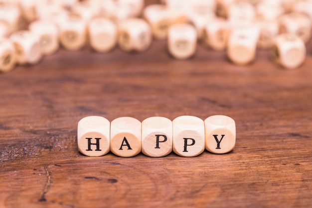 Free photo happy word written on cubes shape wooden blocks