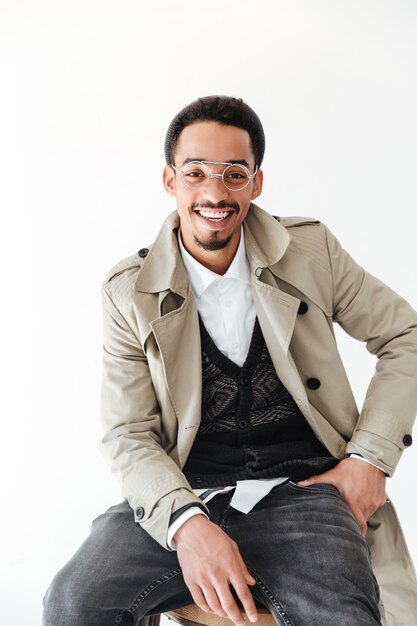 Happy young african man sitting isolated