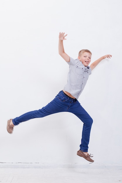 Free Photo happy young boy jumping  on white background