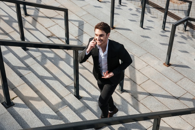 Happy young businessman walking outdoors