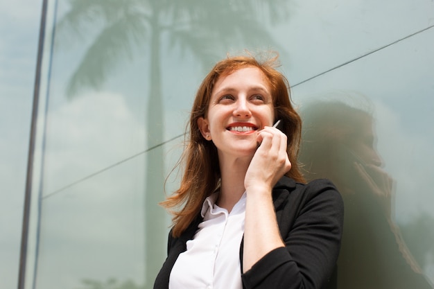 Free photo happy young businesswoman talking on cellphone