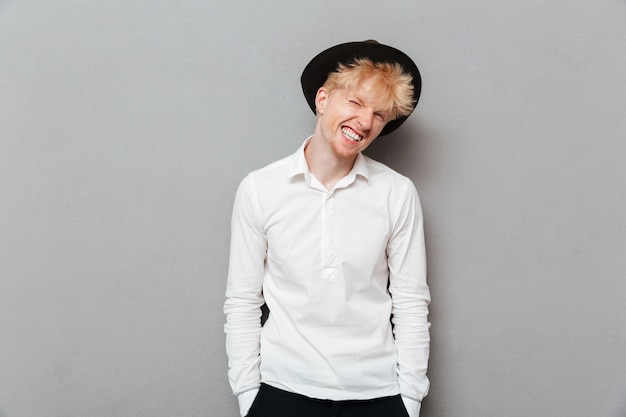 Happy young caucasian man standing isolated