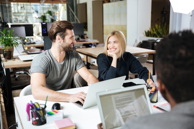 Happy young colleagues sitting in office coworking