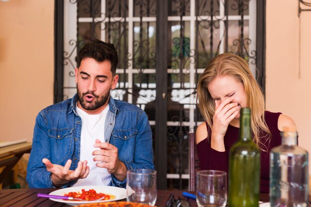 Happy young couple enjoying meal at restaurant