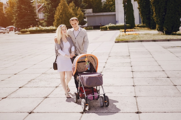 Happy young couple posing with a stroller