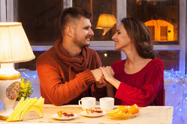 happy young couple with cups of tea