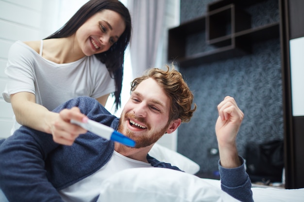 Happy young couple with pregnancy test