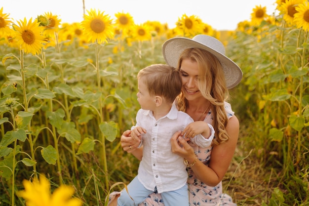 Free Photo happy young family, mother father and son, are smiling, holding and hugging in the sunflower field