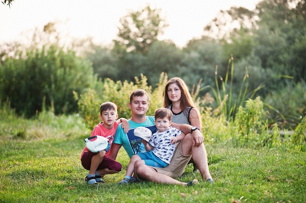 Happy young family mother father two children son on nature having fun