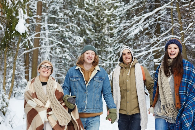 Happy Young Friends in Winter Forest