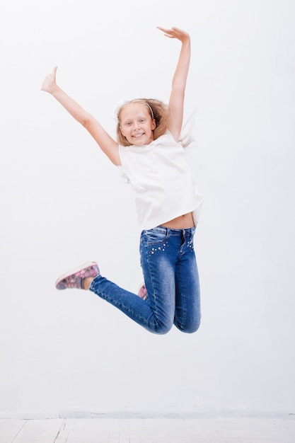 Free photo happy young girl jumping over a white background