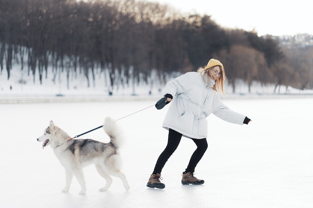 Free Photo happy young girl playing with siberian husky dog in winter park