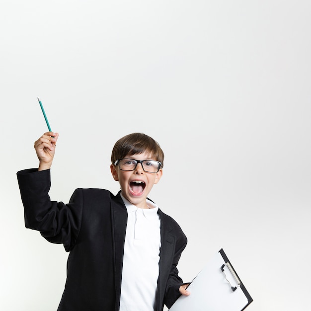 Happy young kid in a suit with glasses