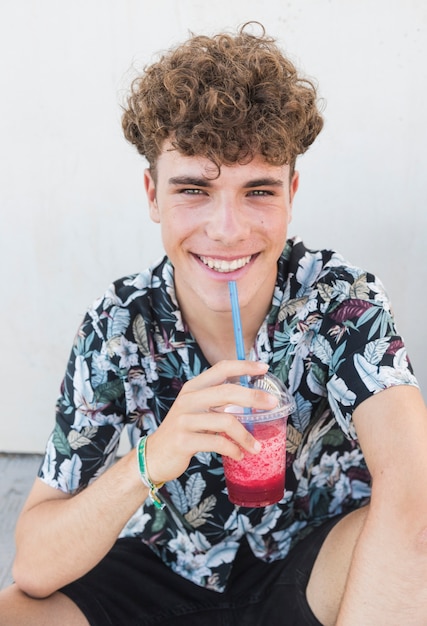 Free photo happy young man drinking juice