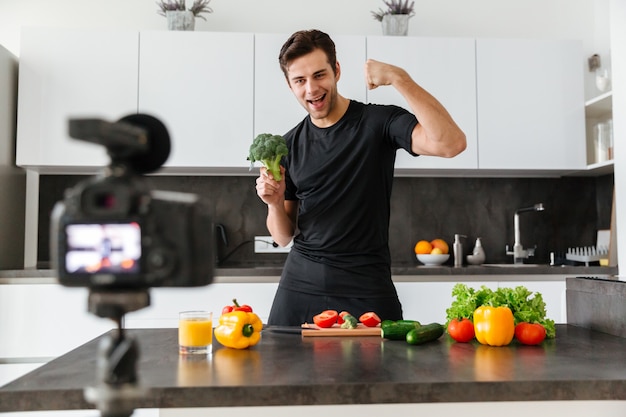 Happy young man filming his video blog episode