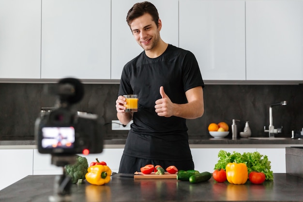 Free photo happy young man filming his video blog episode