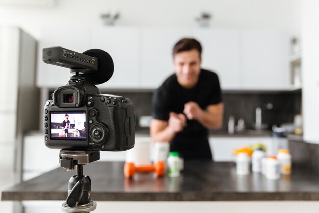 Happy young man filming his video blog episode