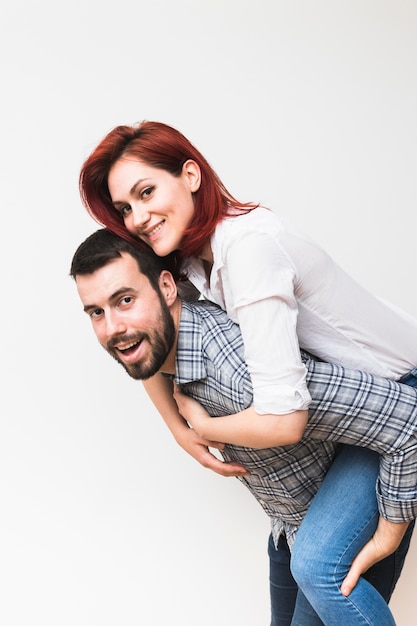 Happy young man piggybacking his wife