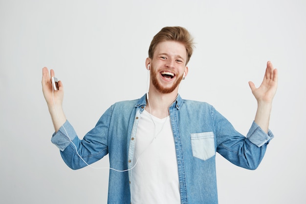 Free Photo happy young man smiling listening to streaming music in headphones singing.