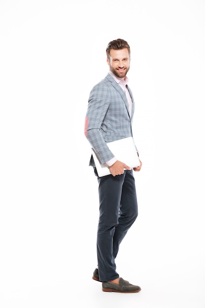 Happy young man standing isolated laptop computer