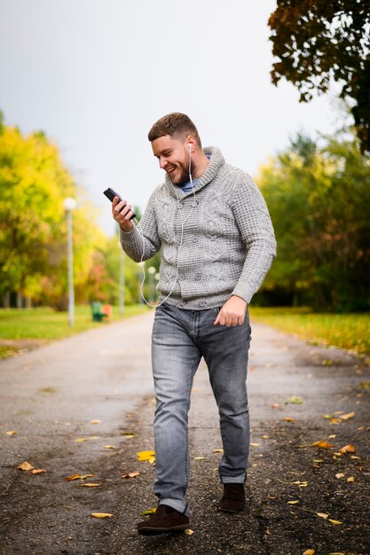 Happy young man walking through the park