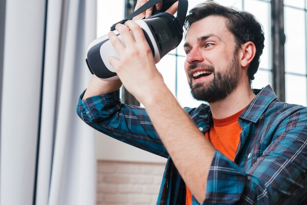 Happy young man wearing virtual reality goggles