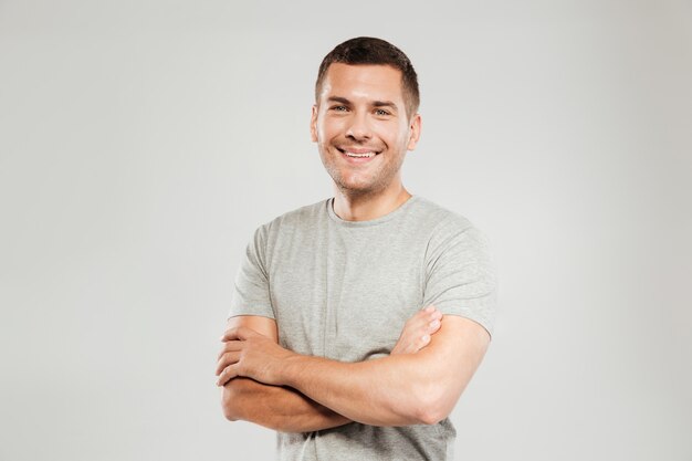 Happy young man with arms crossed.