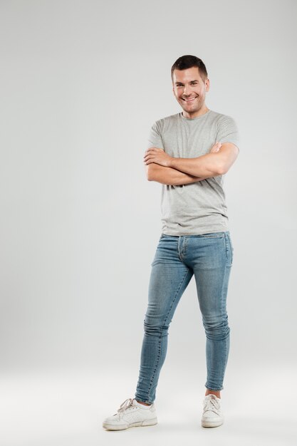 Happy young man with arms crossed.