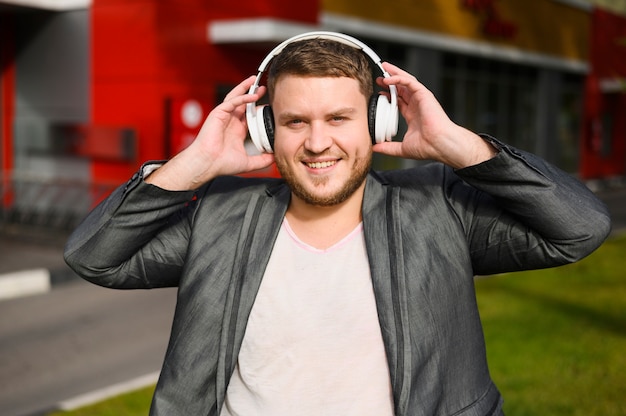 Free photo happy young man with headphones on his ears